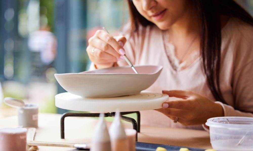 Cropped shot of a young woman painting ceramics in an art studio